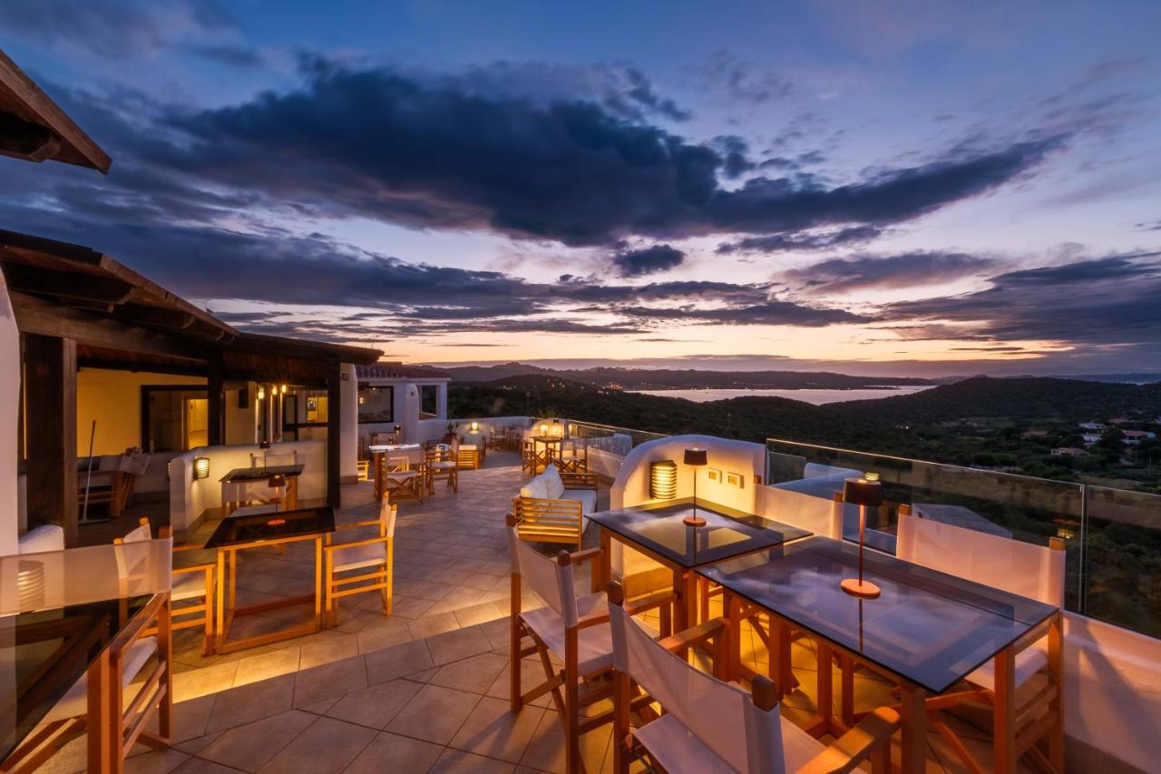 een uitzicht vanaf het balkon van een huis met tafels en stoelen bij Hotel Pedra Santa in Baja Sardinia