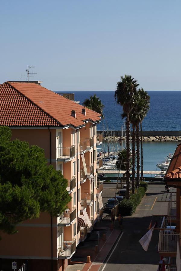 een uitzicht op een gebouw met palmbomen en de oceaan bij Hotel Bergamo Mare Mhotelsgroup in San Bartolomeo al Mare