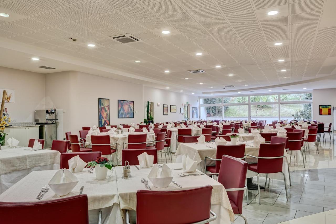 een feestzaal met witte tafels en rode stoelen bij Residence Eden in Peschiera del Garda