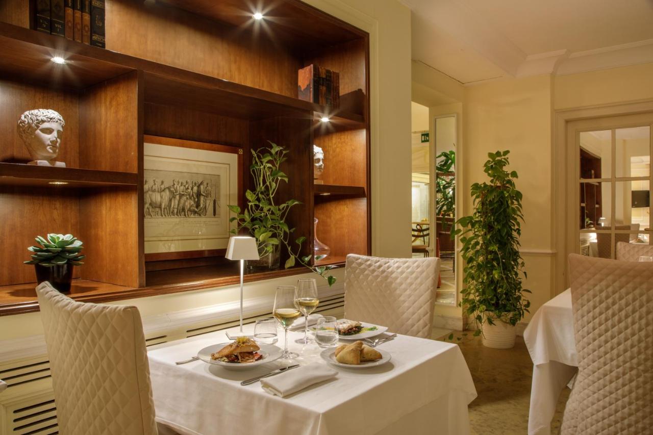 een eetkamer met een tafel vol eten en wijnglazen bij Donna Laura Palace by OMNIA hotels in Rome