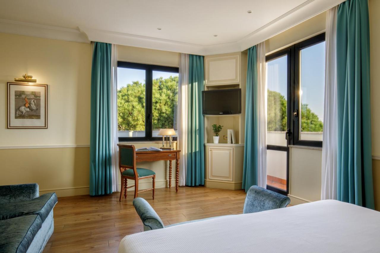 een hotelkamer met een bed en een bureau bij Donna Laura Palace by OMNIA hotels in Rome