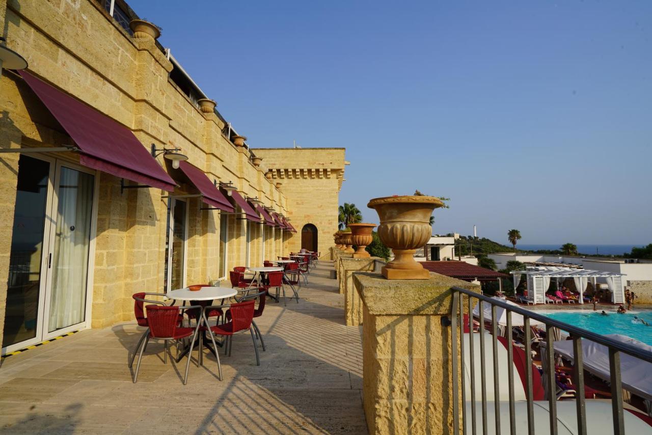 een balkon met tafels en stoelen naast een zwembad bij Messapia Hotel & Resort in Marina di Leuca