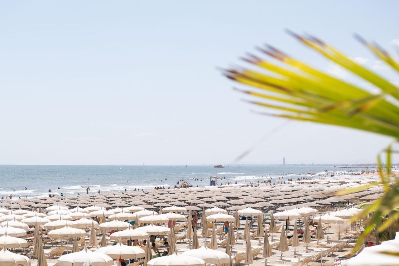 een strand vol witte parasols en de oceaan bij Hotel King - Azzurro Club in Milano Marittima