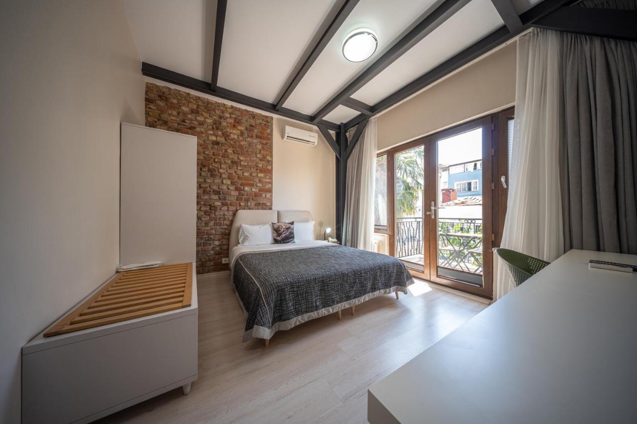 een slaapkamer met een bed en een groot raam bij Calanthe Residence in Istanbul