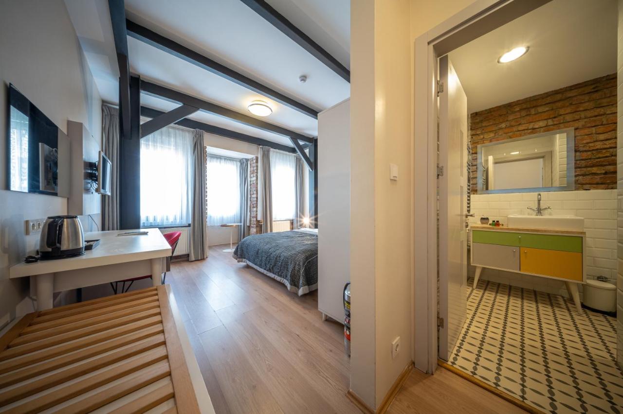 een slaapkamer met een bed en een badkamer met een wastafel bij Calanthe Residence in Istanbul