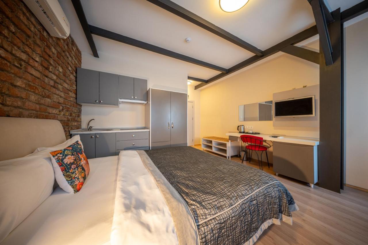 een slaapkamer met een bed en een bureau in een kamer bij Calanthe Residence in Istanbul