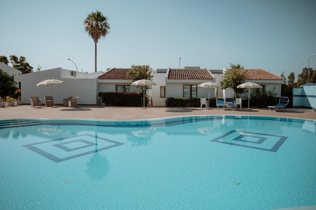 Zwembad omringd door palmbomen — Fior di Sardegna Resort