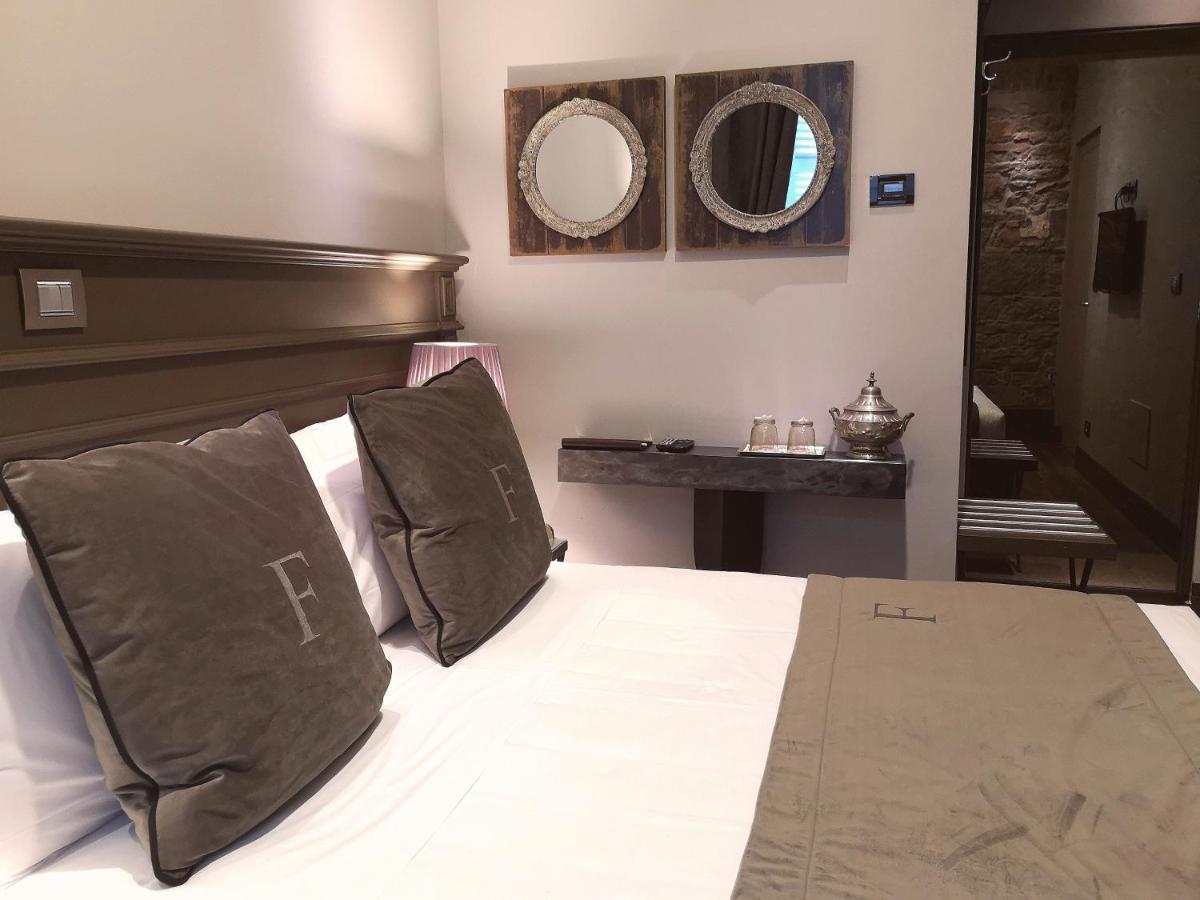 een slaapkamer met een bed en twee spiegels aan de muur bij Forvm boutique Hotel in Trieste +55 foto's
