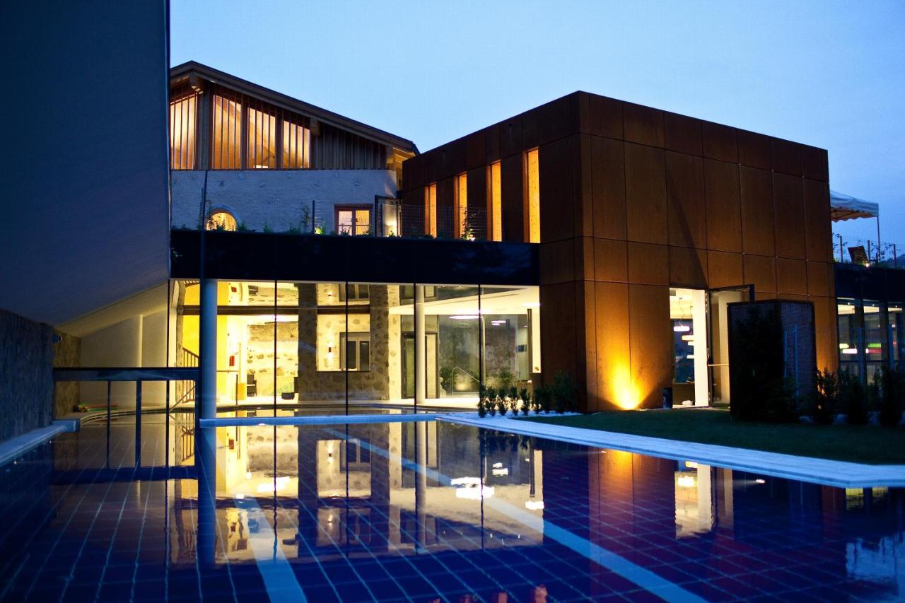 een gebouw met een zwembad ervoor bij Hotel Grüner Baum in Bressanone