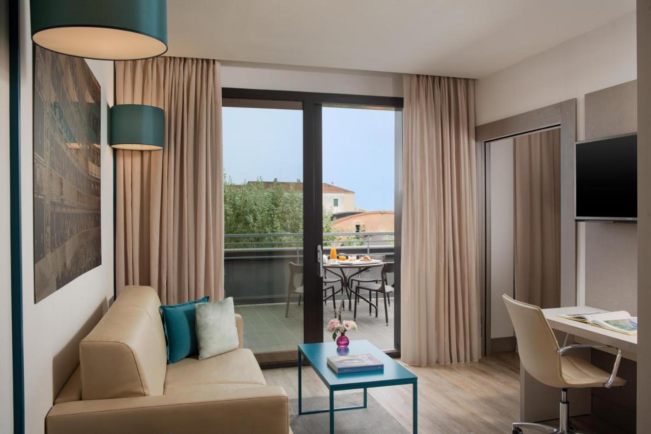 een woonkamer met een bank en een tafel bij NH Parma in Parma