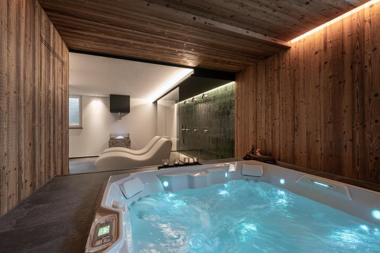 een jacuzzi in een kamer met houten wanden bij Hotel alle Rose Family inspired garden and SPA in Cavedago