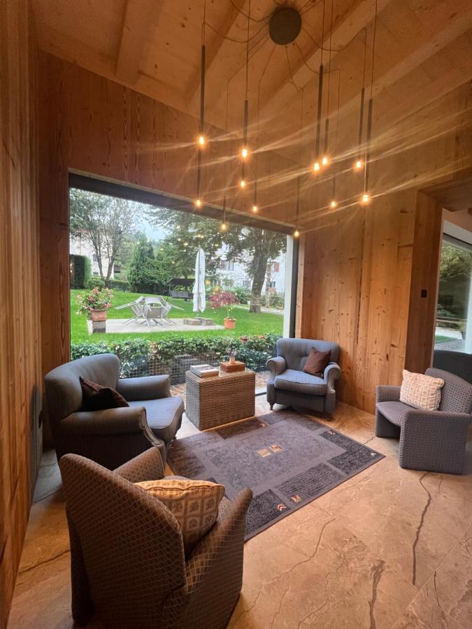 een woonkamer met meubels en een groot raam bij Hotel alle Rose Family inspired garden and SPA in Cavedago