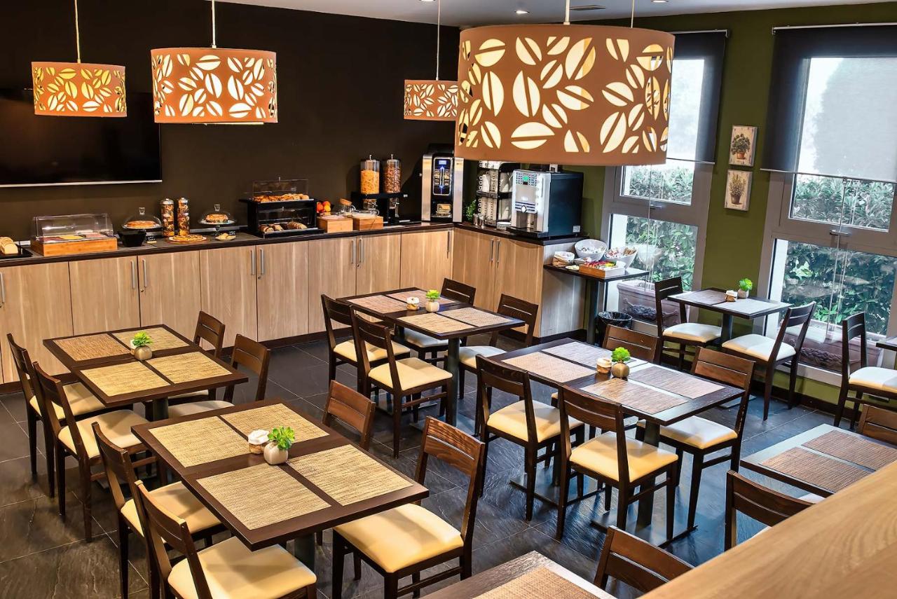 een restaurant met houten tafels en stoelen en ramen bij Hotel Roma Sud in Frascati