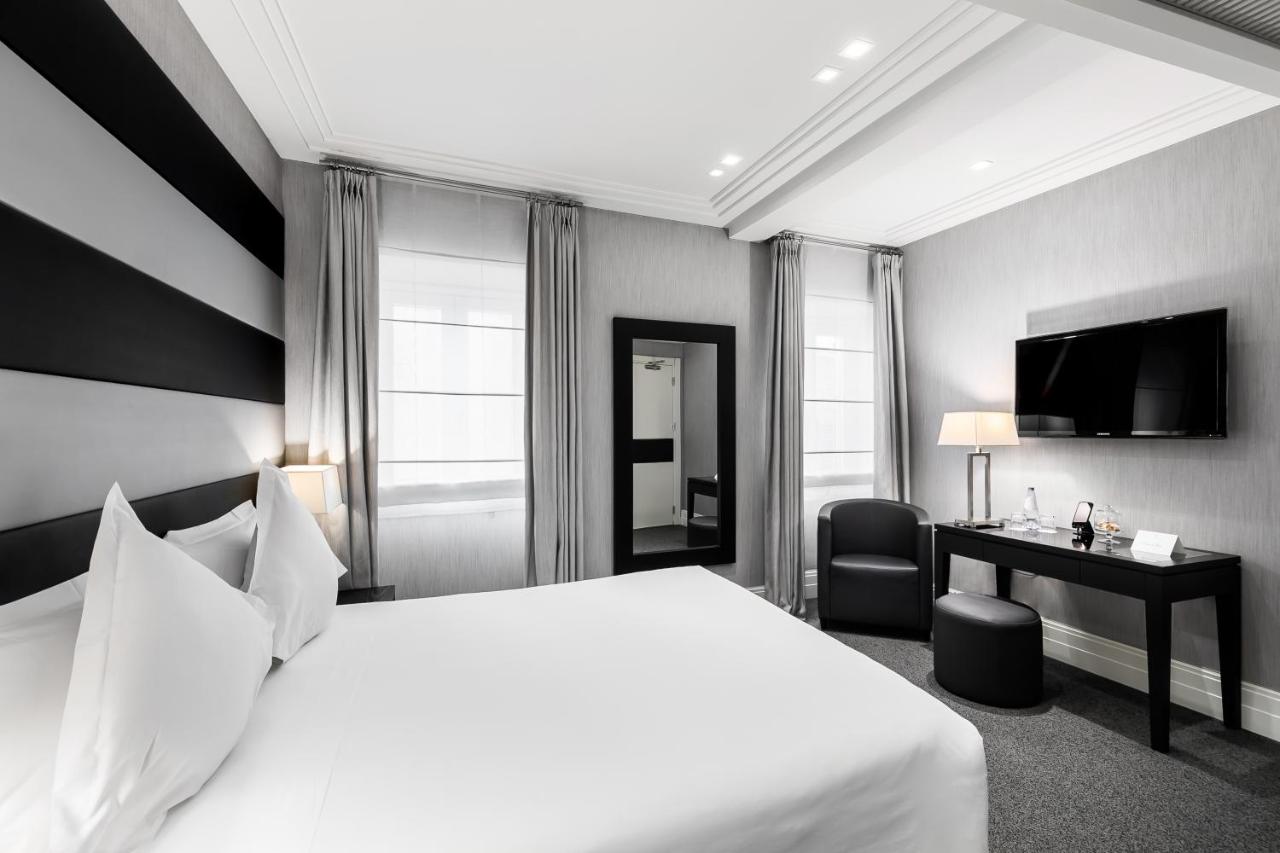 een hotelkamer met een wit bed en een bureau bij Hotel Mancino 12 in Rome