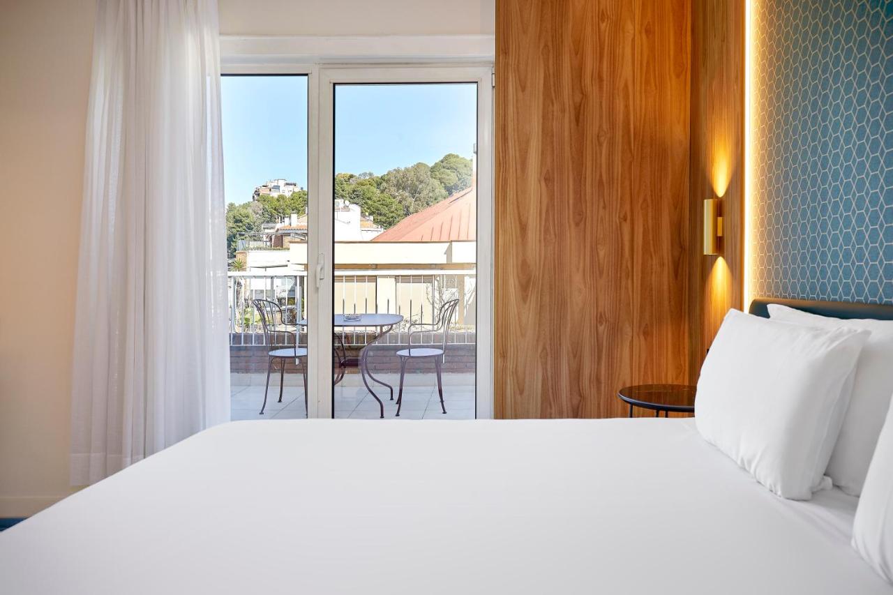 een slaapkamer met een bed en uitzicht op een patio bij Exe Mitre in Barcelona