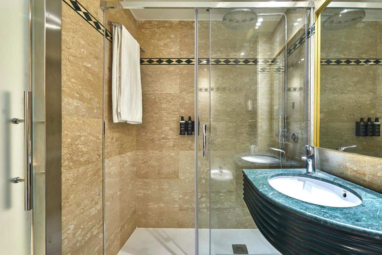 een badkamer met een wastafel en een glazen douche bij Exe Mitre in Barcelona