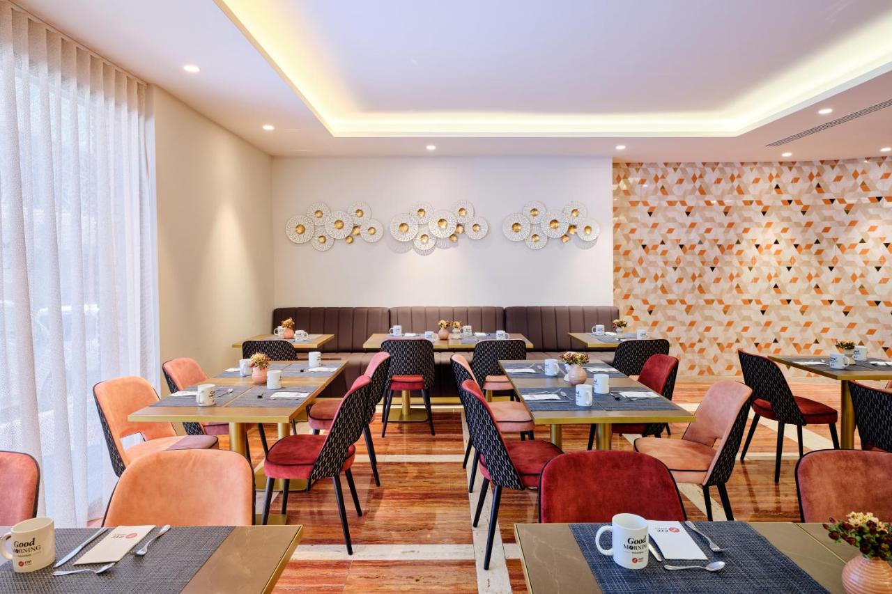een restaurant met tafels en stoelen en een groot raam bij Exe Mitre in Barcelona
