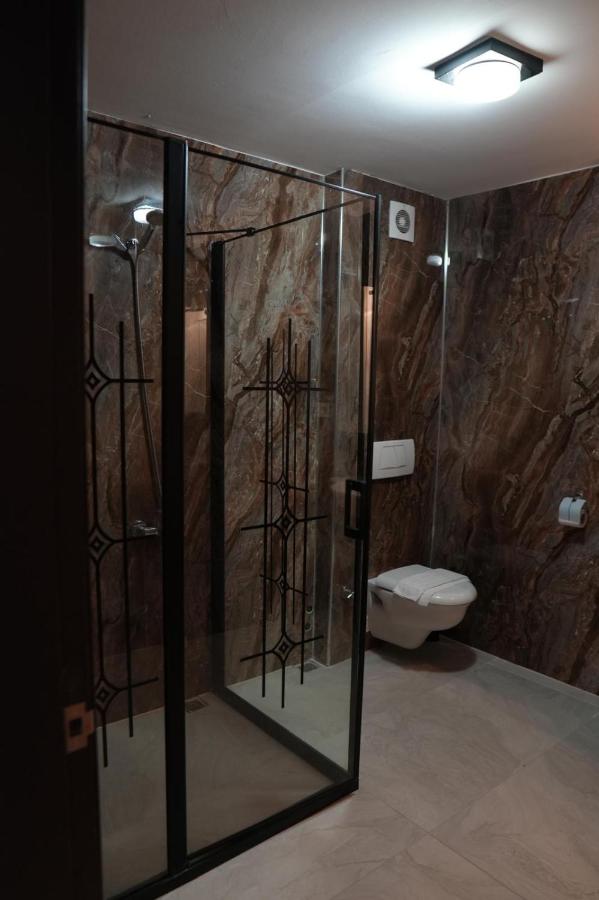 een badkamer met een glazen douchecabine en een toilet bij Comfort Downtown Istanbul Hotel in Istanbul