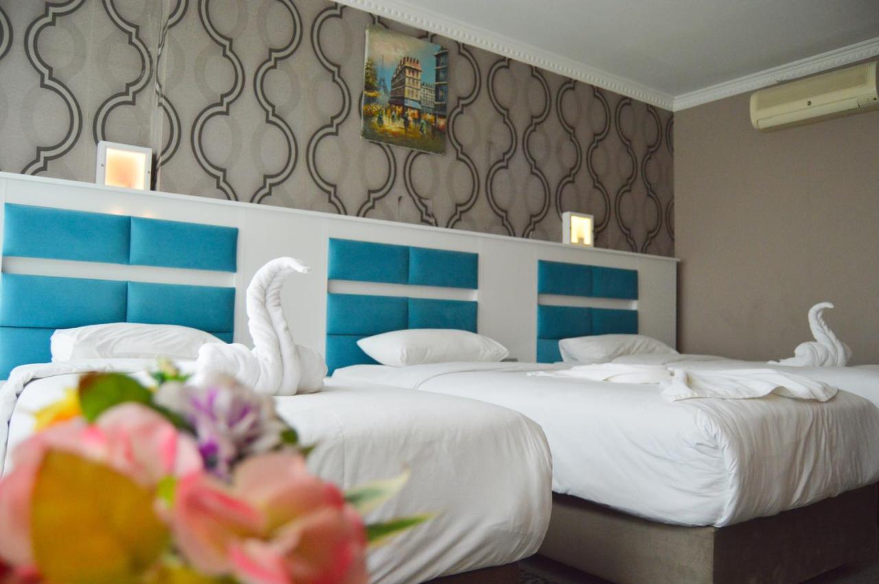 Twee bedden in een hotelkamer met twee zwanen. bij Comfort Downtown Istanbul Hotel in Istanbul