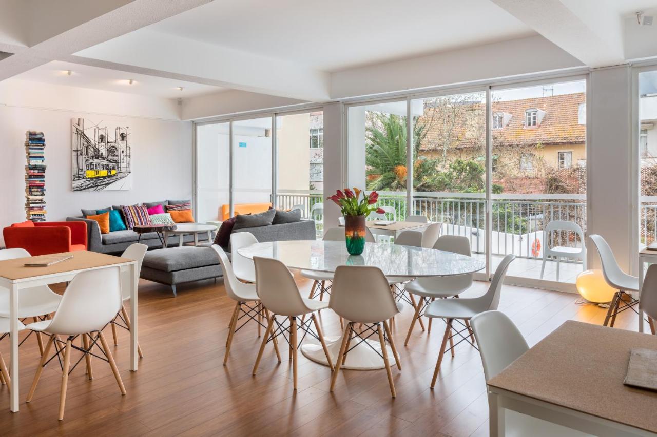 een woonkamer met een tafel en stoelen bij Hotel Londres Estoril / Cascais in Estoril