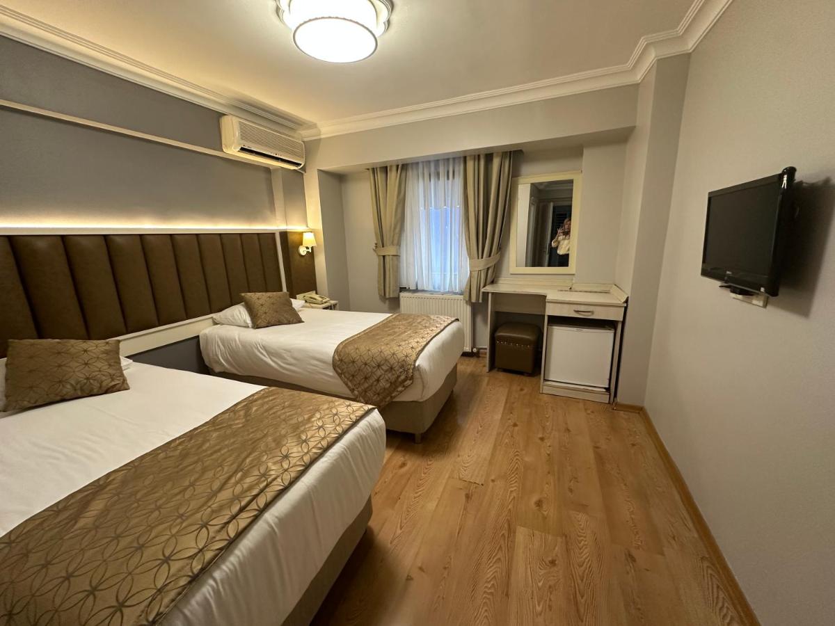 een hotelkamer met twee bedden en een televisie bij Hotel Süreyya in Istanbul