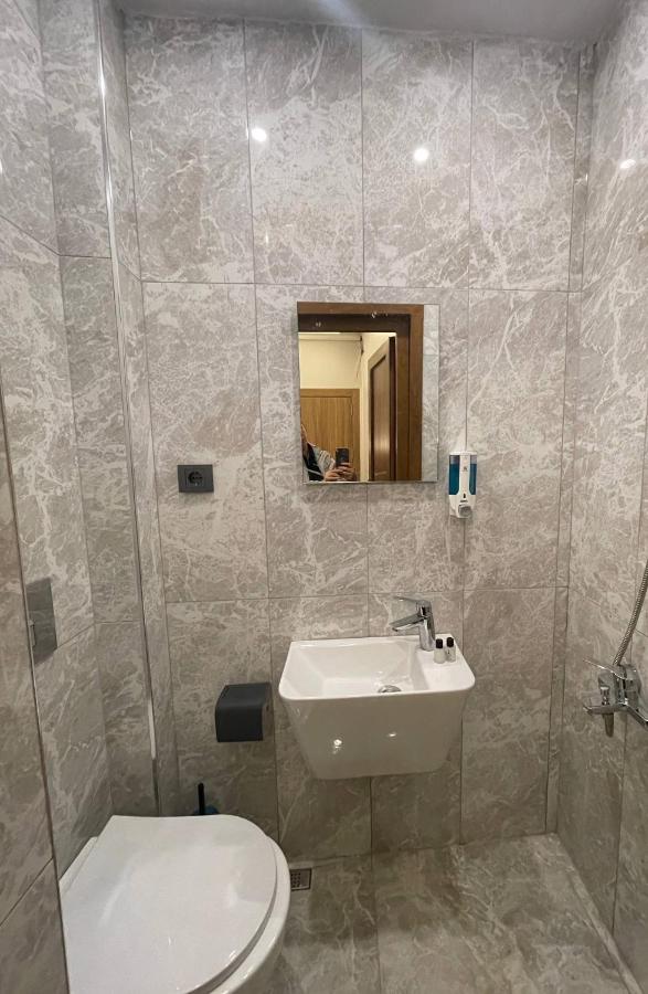 een badkamer met een wastafel, een toilet en een spiegel bij Hotel Bergama in Istanbul