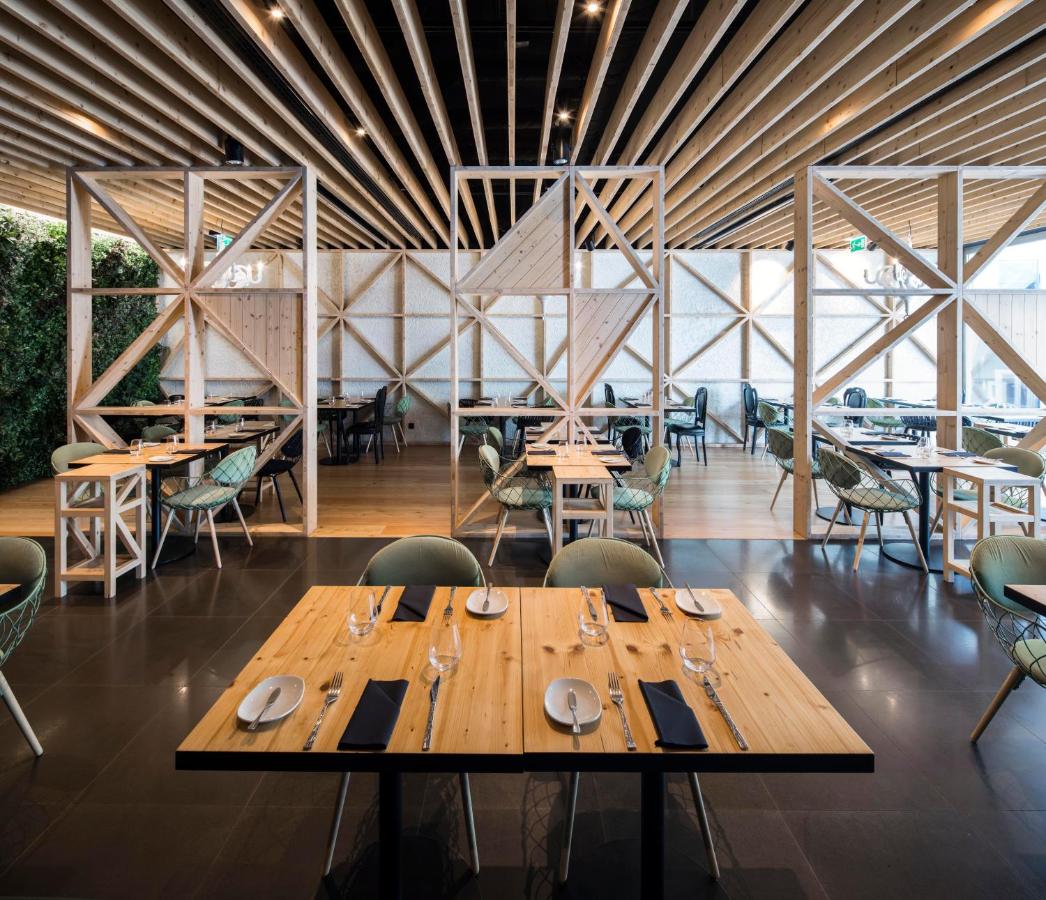 een eetkamer met houten tafels en stoelen bij BessaHotel Liberdade in Lissabon