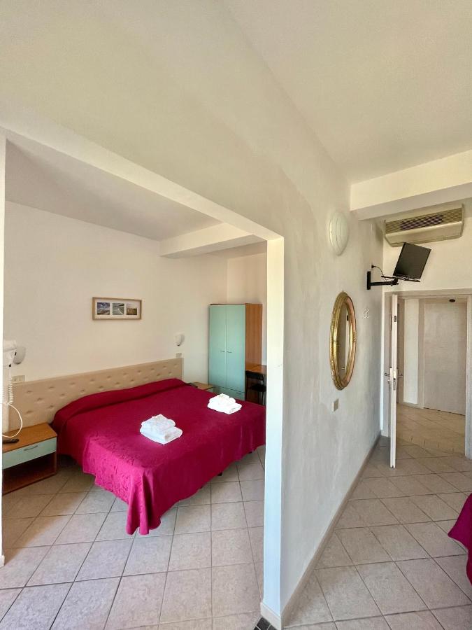 een slaapkamer met een rood bed in een kamer bij Hotel Blumen in Rimini