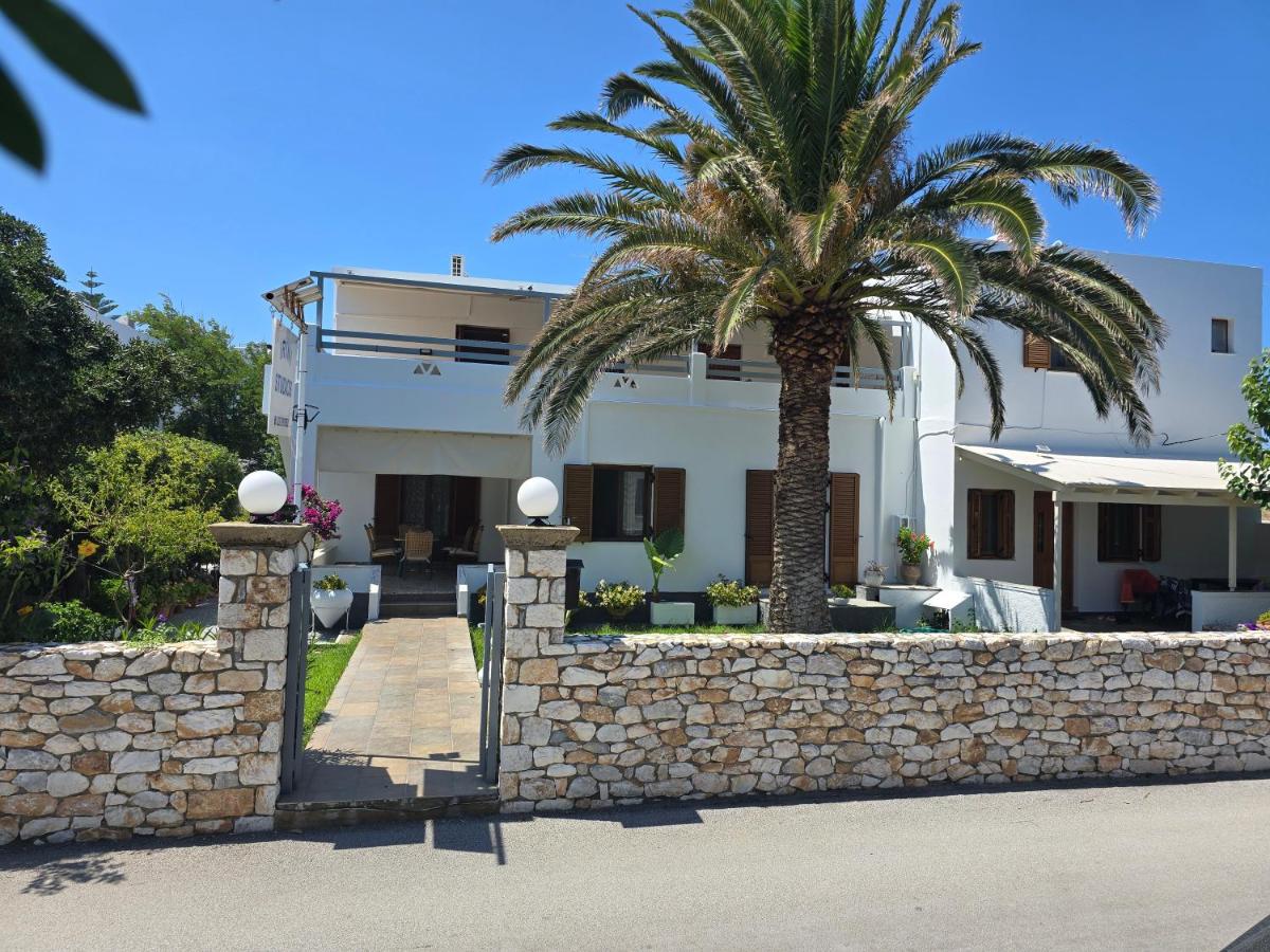 een huis met een palmboom en een stenen muur bij Irini studios in Skiros