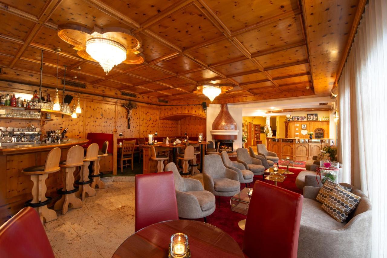 een restaurant met tafels en stoelen en een bar bij Hotel Engel in Sluderno