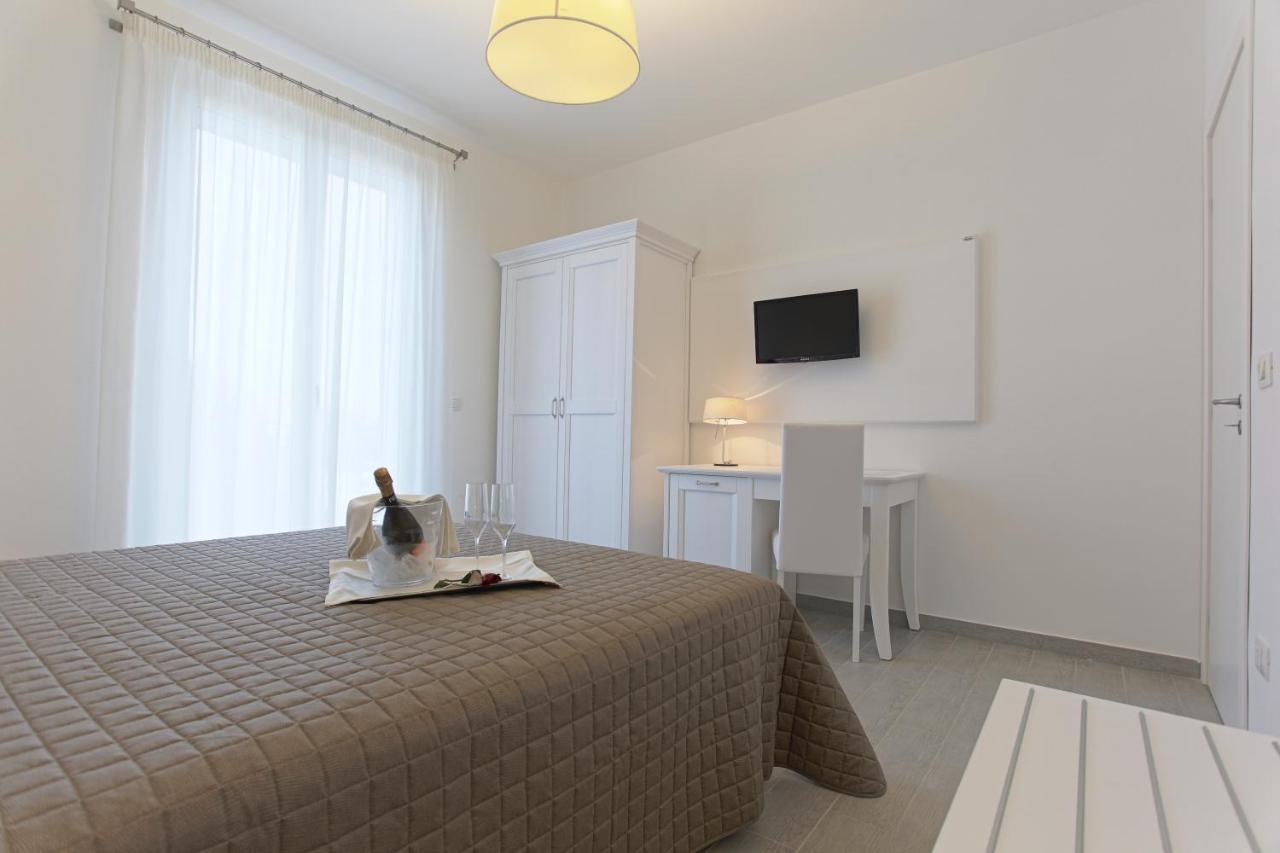 een slaapkamer met een bed, een tafel en een televisie bij Scala Dei Turchi Resort in Realmonte