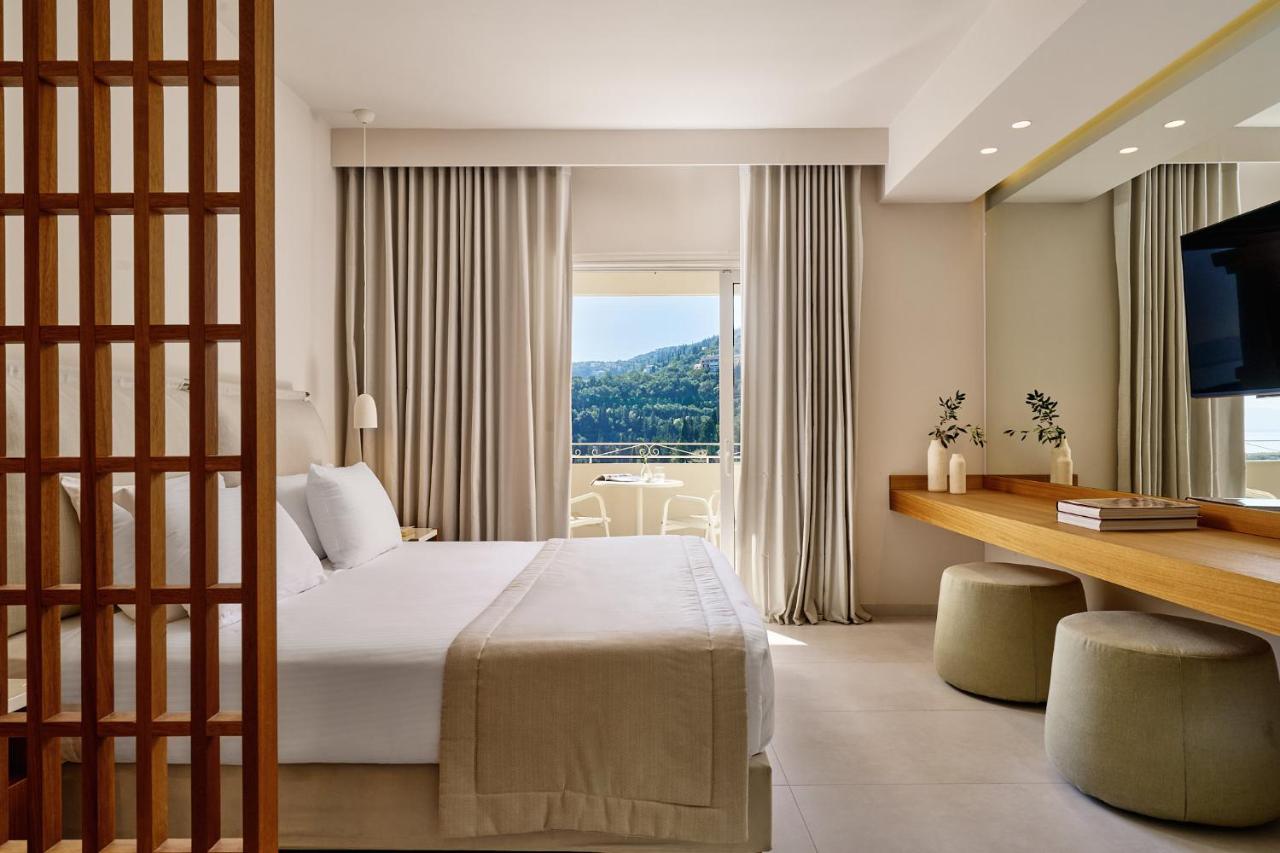 een hotelkamer met een bed en een groot raam bij San Antonio Corfu Resort (Adults Only) in Kalámi