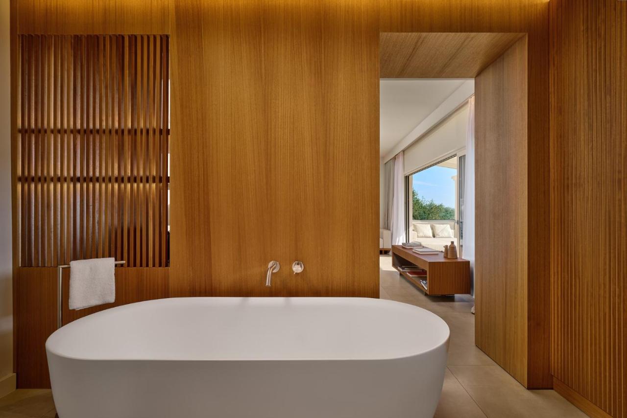 een badkamer met een groot wit bad in een kamer bij San Antonio Corfu Resort (Adults Only) in Kalámi