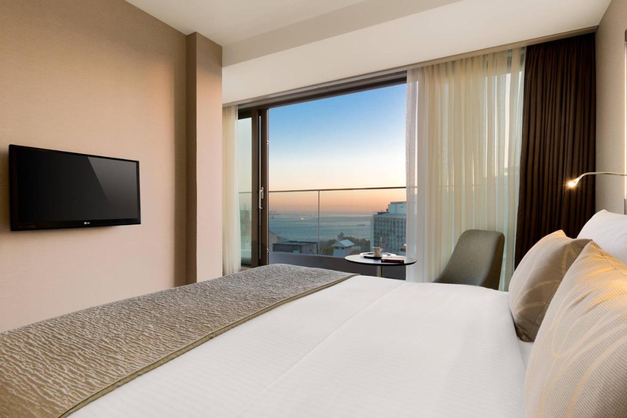 een hotelkamer met een bed en een groot raam bij AC Hotel Istanbul Macka in Istanbul