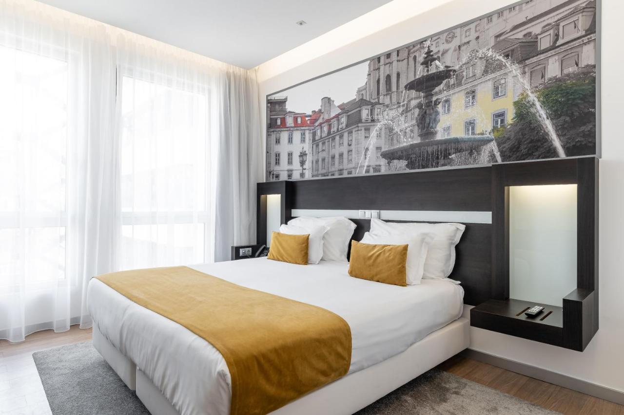 een slaapkamer met een groot bed en een groot schilderij aan de muur bij Jupiter Lisboa Hotel - Rooftop & Spa in Lissabo