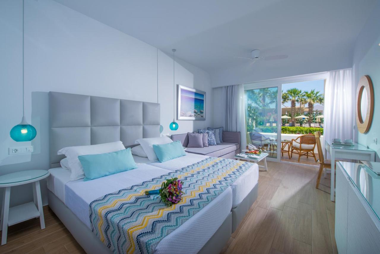 een slaapkamer met een groot bed en een woonkamer bij Rethymno Palace in Adelianos Kampos