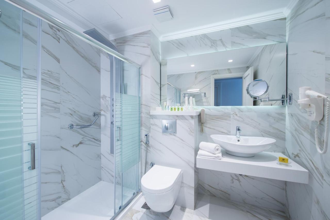 een badkamer met een toilet, een wastafel en een douche bij Rethymno Palace in Adelianos Kampos
