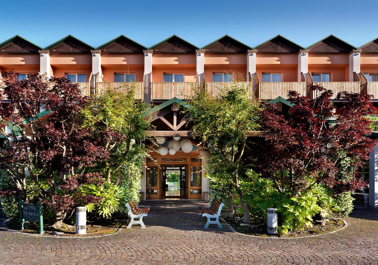 een groot gebouw met bomen ervoor bij Iseo Lago Hotel in Iseo