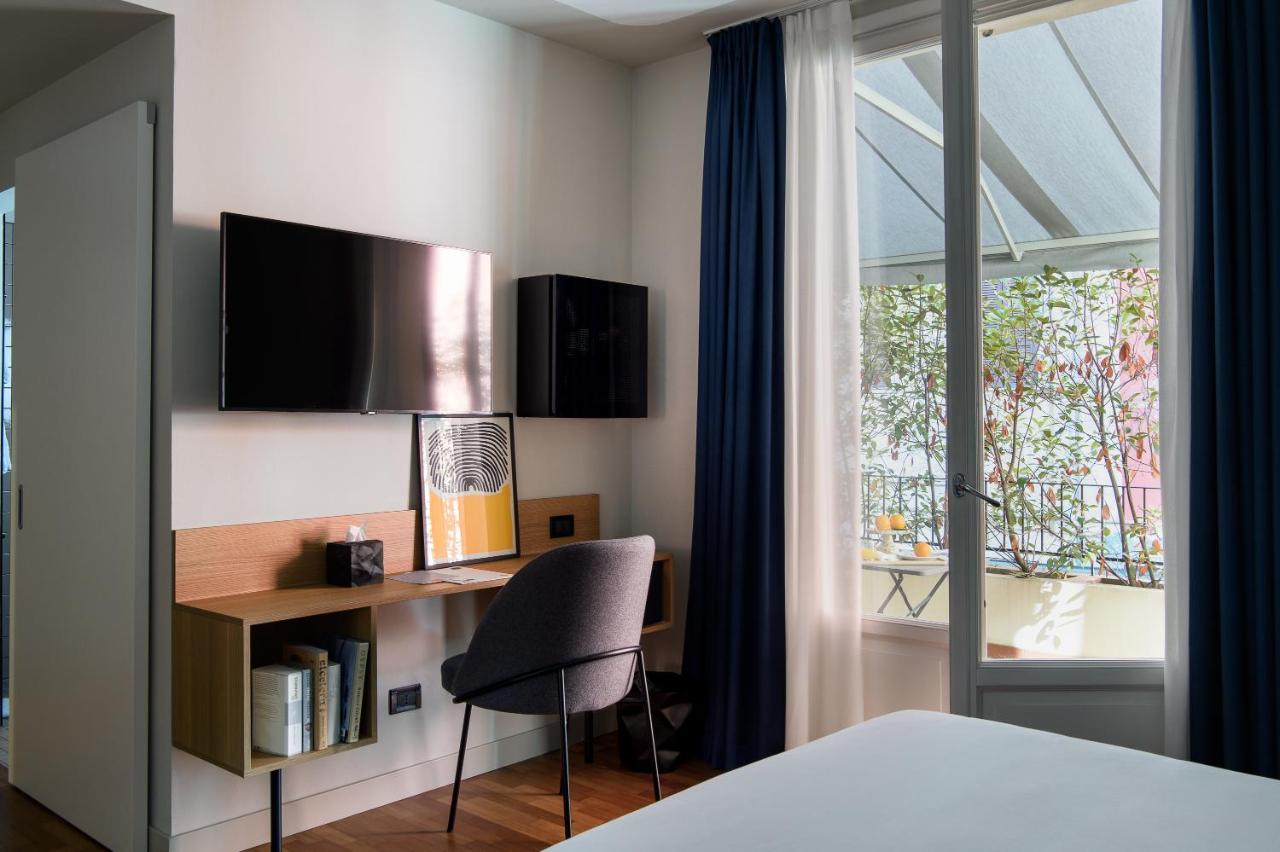 een slaapkamer met een bureau, een stoel en een raam bij The Poet Hotel in La Spezia