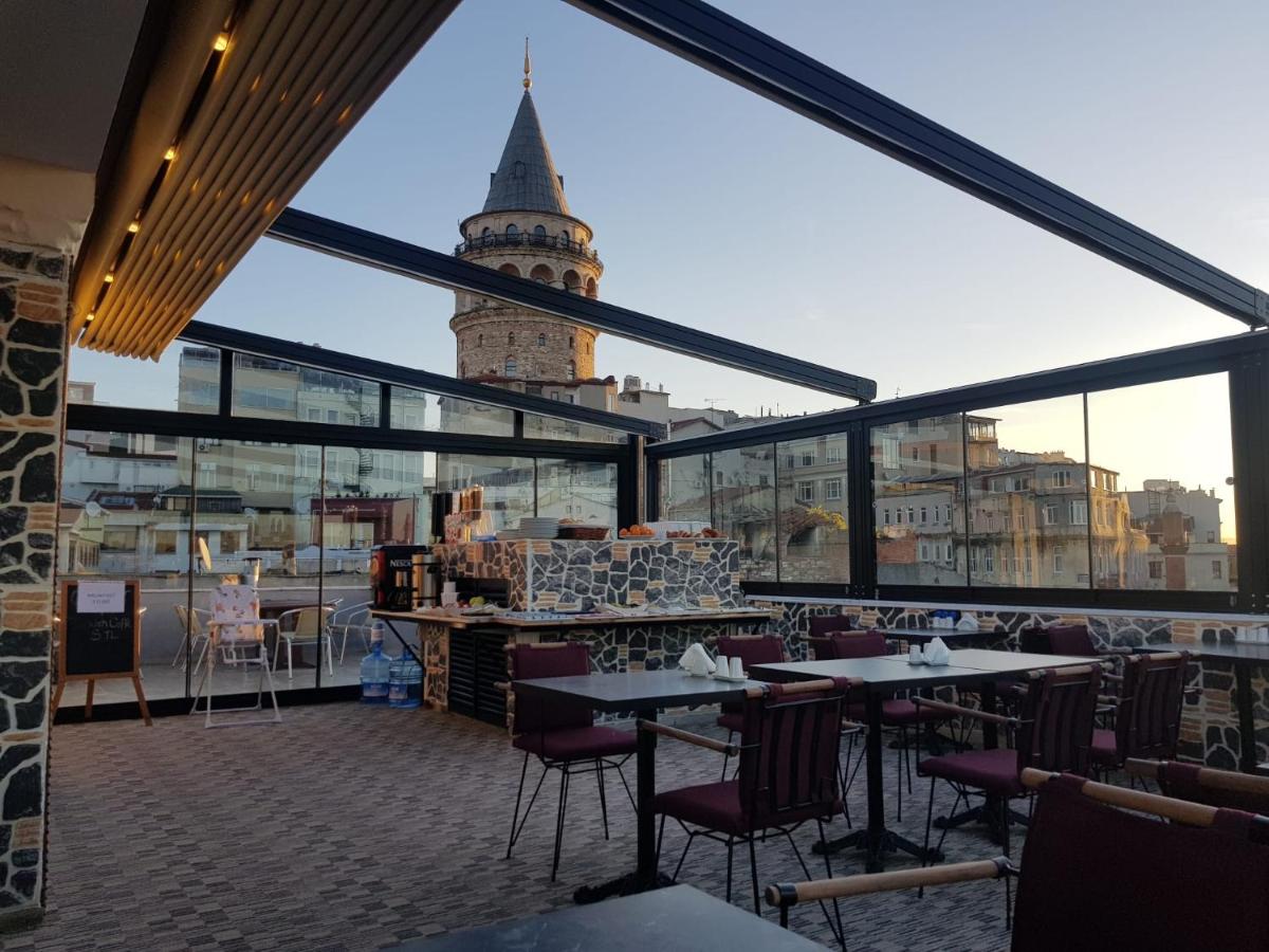een restaurant met uitzicht op een klokkentoren bij Galatower Hotel in Istanbul