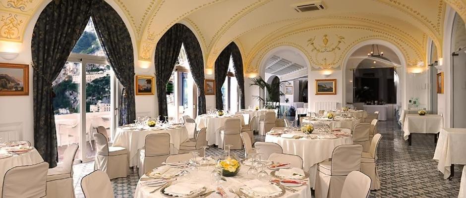 een eetkamer met witte tafels en witte stoelen bij Hotel Luna Convento in Amalfi