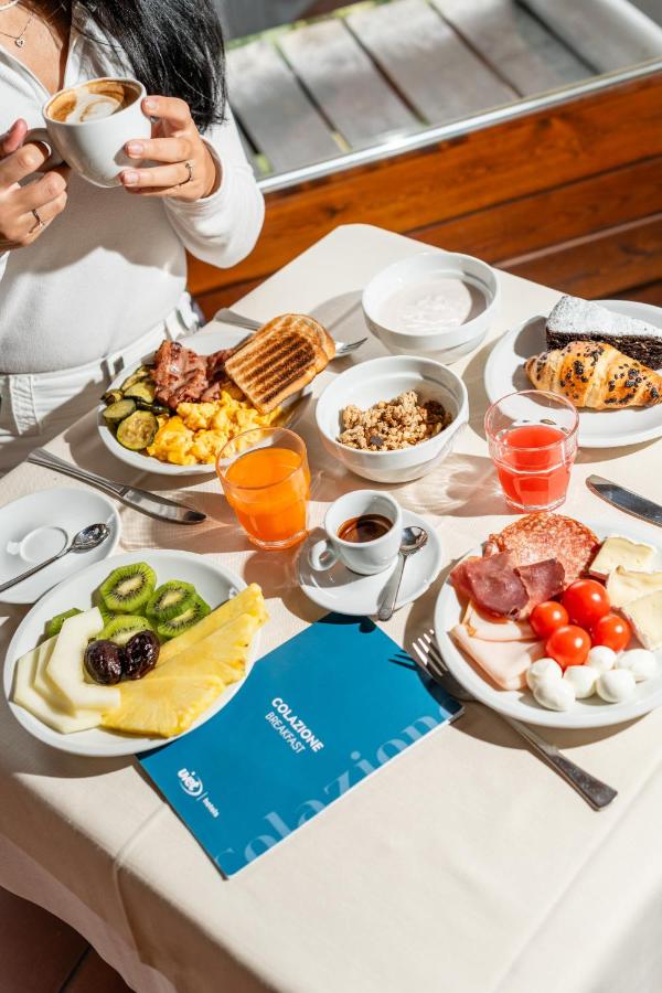 een tafel met borden eten erop bij Hotel Les Jumeaux Courmayeur in Courmayeur