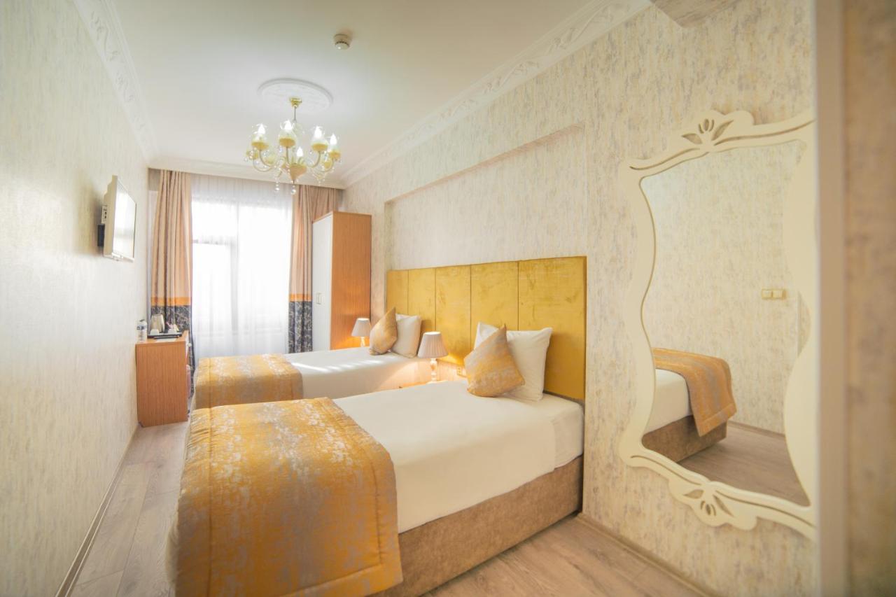 een hotelkamer met twee bedden en een kroonluchter bij Istanbul Old City Sultanahmed Miran Hotel in Istanbul