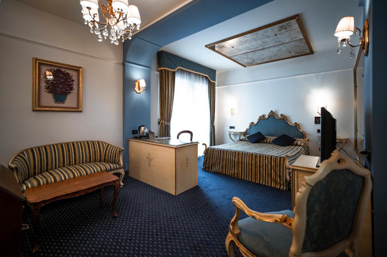 een slaapkamer met een bed, een bank en een stoel bij Bonotto Hotel Belvedere in Bassano del Grappa +41 foto's