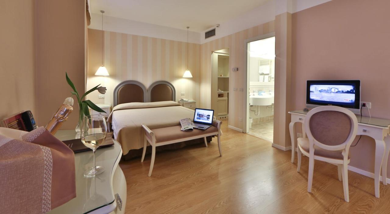 een hotelkamer met een slaapkamer met een bed en een televisie bij Bonotto Hotel Belvedere in Bassano del Grappa