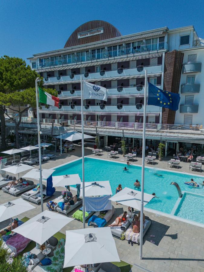 een hotel met een zwembad en een gebouw bij Hotel Cesare Augustus in Lido di Jesolo +144 foto's