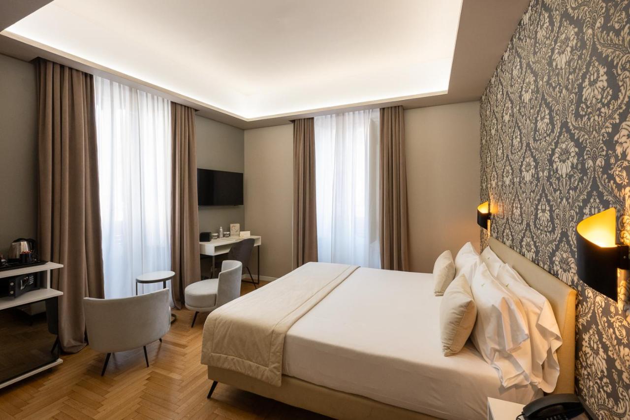 een hotelkamer met een bed en een bureau bij Hotel Caravita in Rome