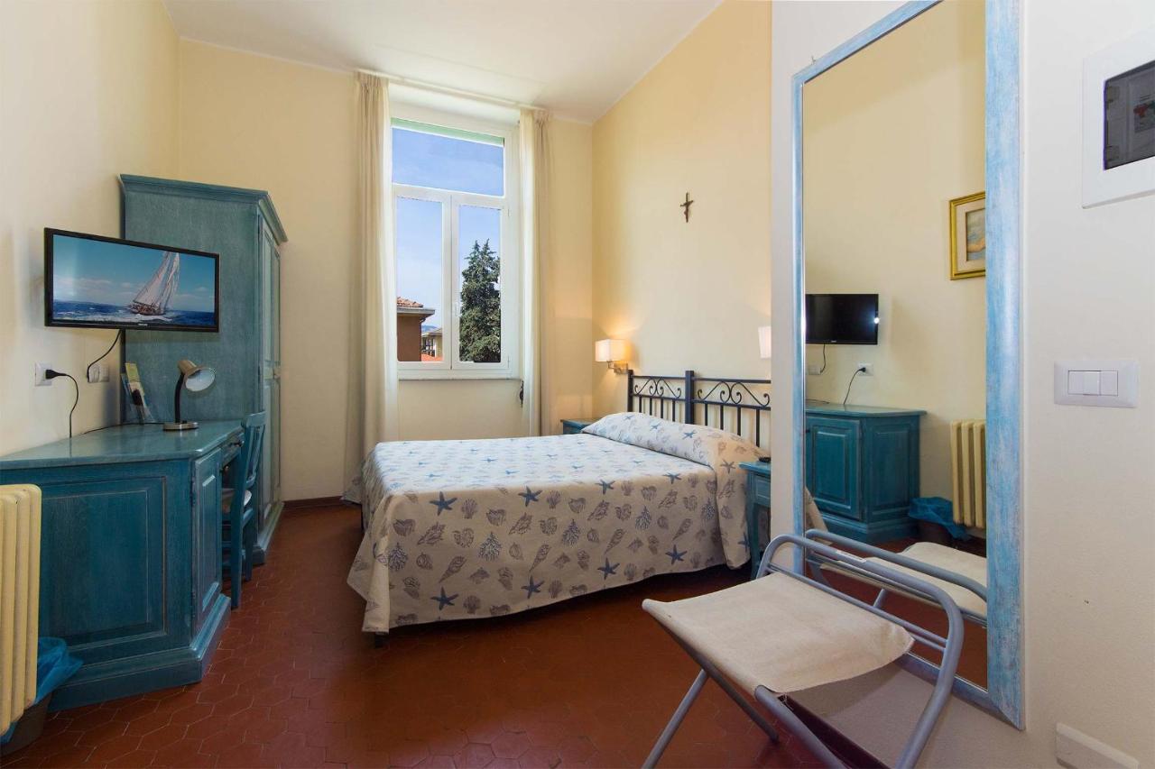 een slaapkamer met een bed en een spiegel bij Hotel Villa San Giuseppe in San Bartolomeo al Mare