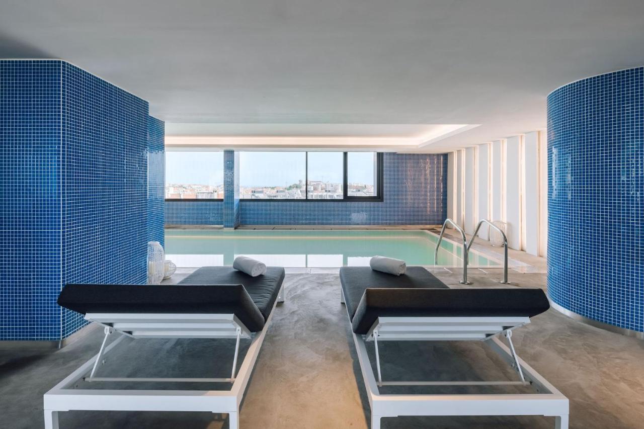 een woonkamer met een zwembad met blauwe tegels bij EVOLUTION Lisboa Hotel in Lissabon