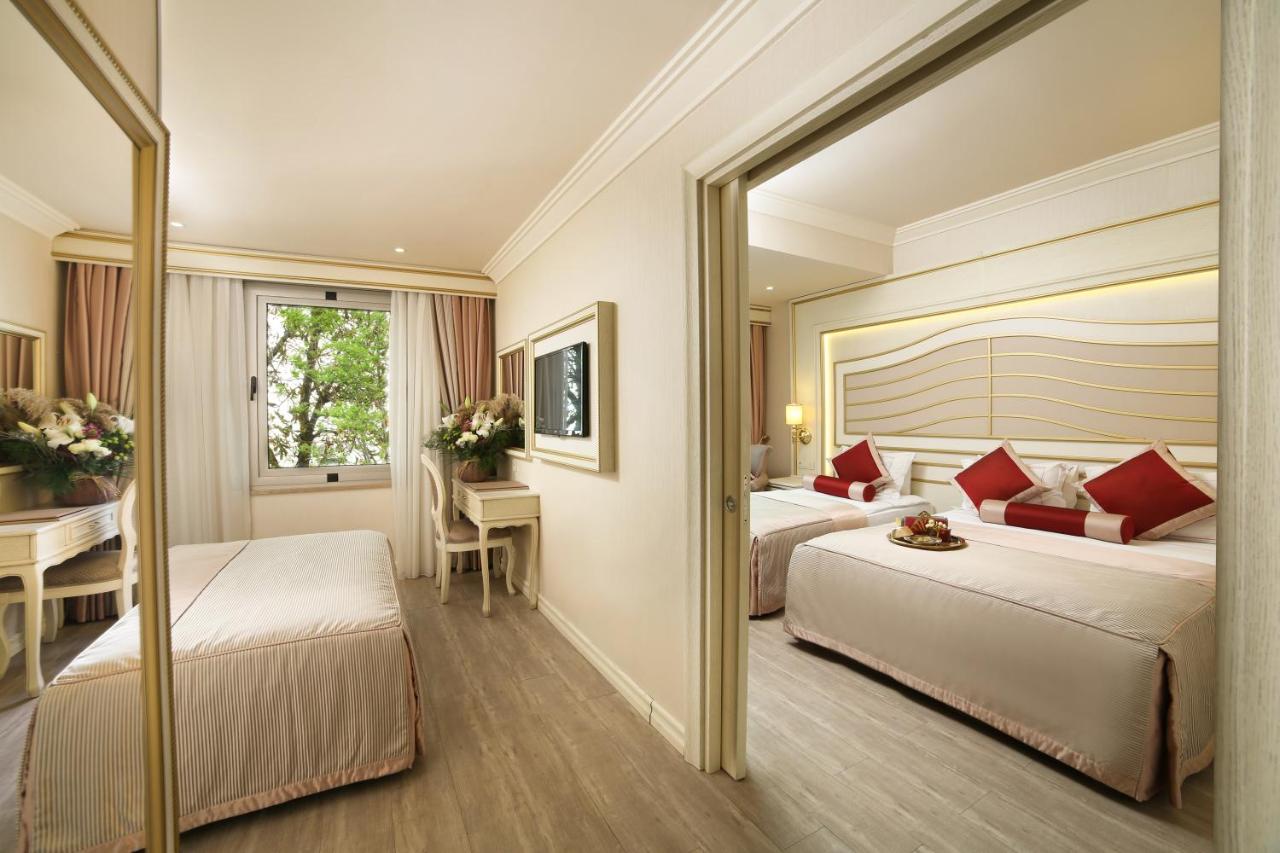 een hotelkamer met twee bedden en een bureau bij Halifaks Hotel in Istanbul